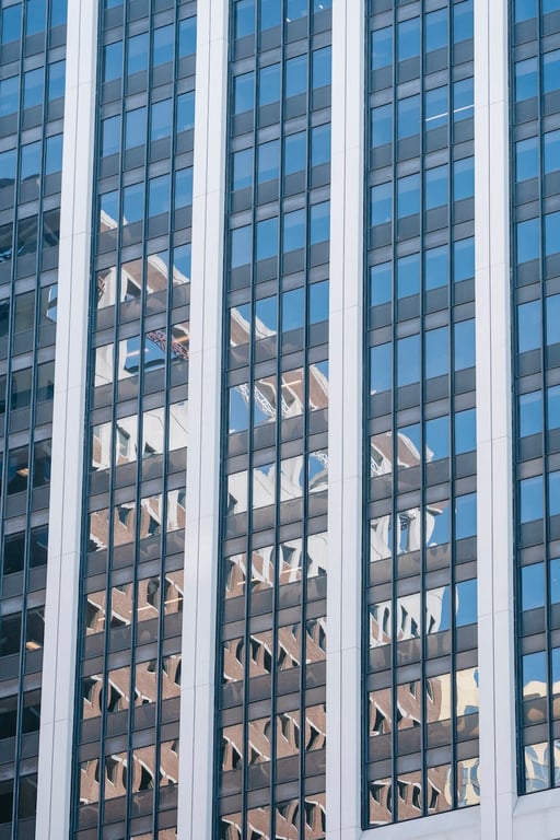 Vue d'en bas d'un gratte-ciel avec des fenêtres à miroirs en verre situé dans un quartier contemporain.